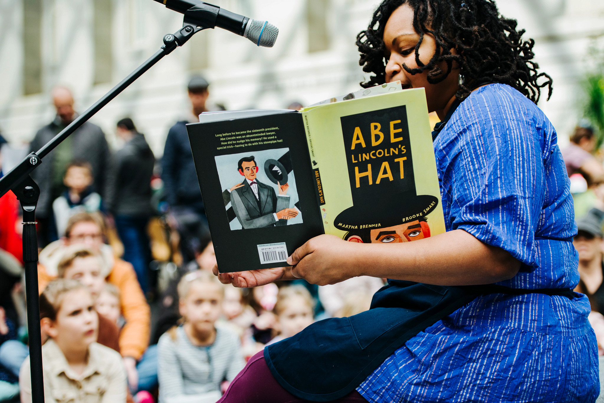 a person reading from a book about abraham lincoln at an event