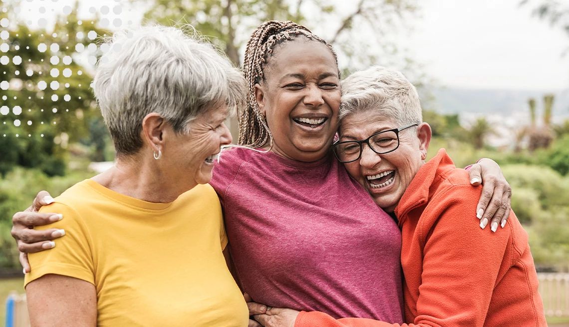 Group of three women hugging outdoors
