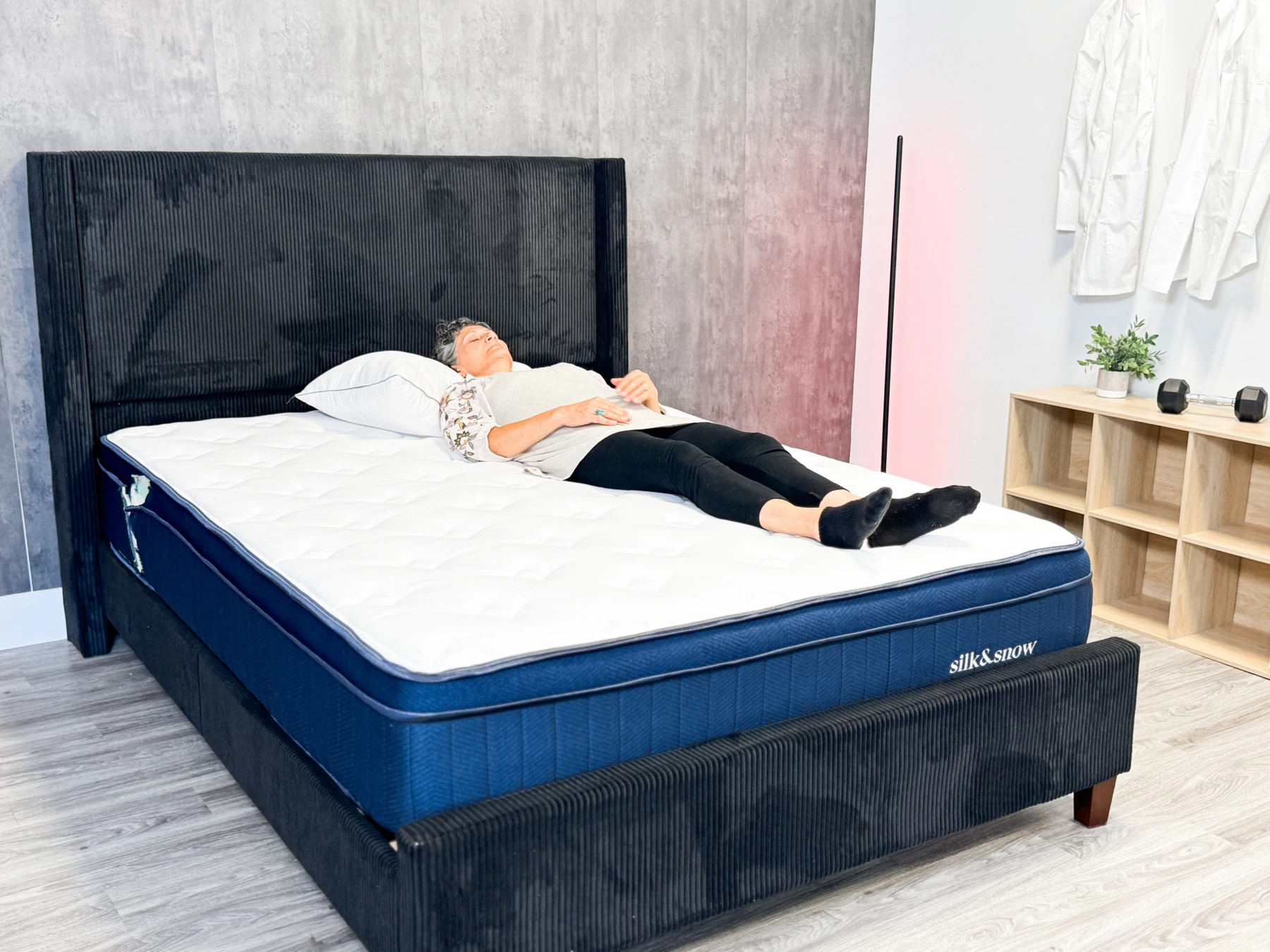 An older adult woman lying on her back on the Silk & Snow hybrid mattress.