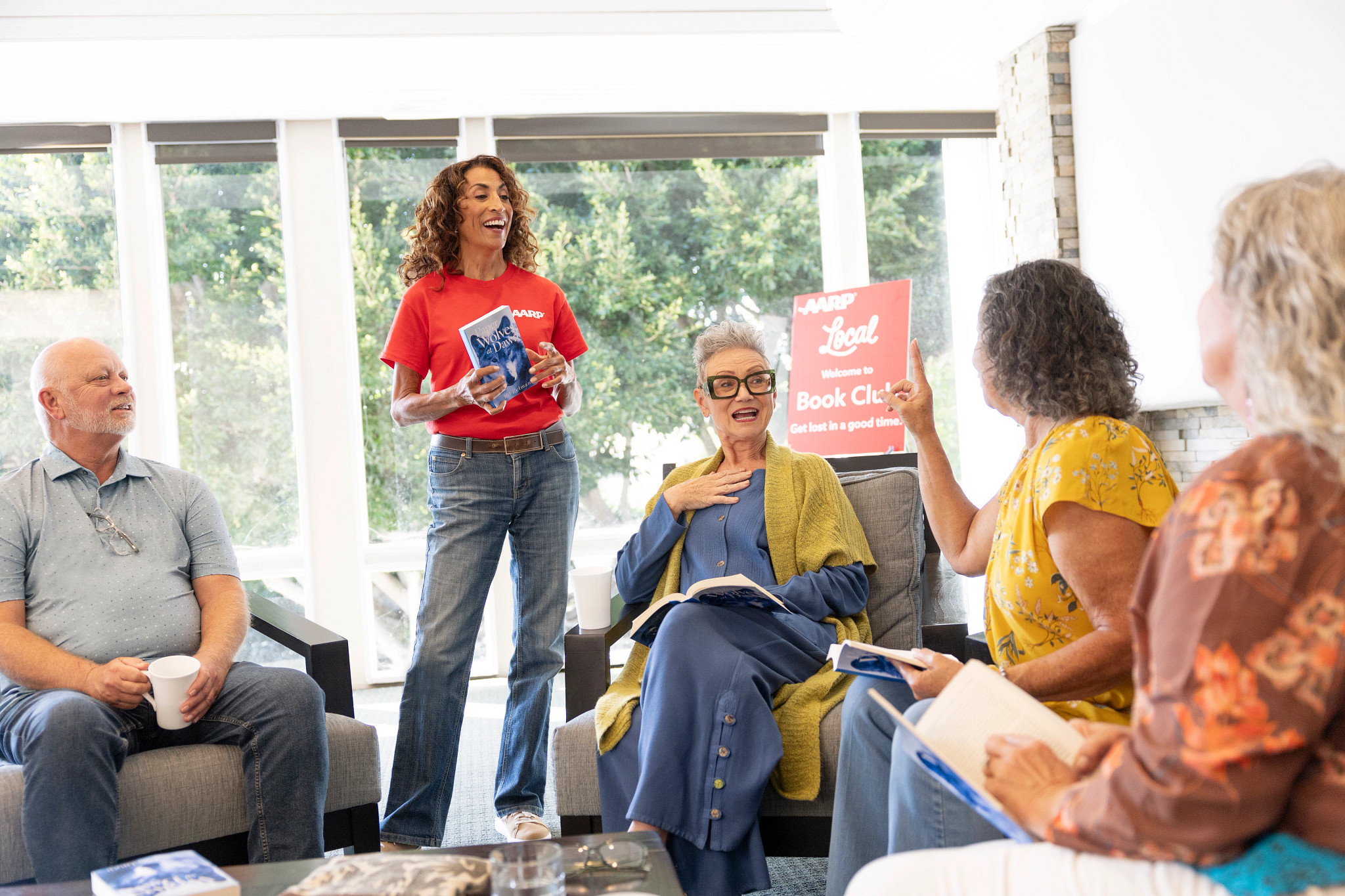 An AARP Local book club facilitator leads a lively discussion as participants share insights about the featured book during a community reading event. Pictured in photo: Thomas Clavell, Cathy Mendoza, Lori Berg, Belinda Keller, Anita St Lewis. CREDIT: Photograph by The Color Bar for AARP.