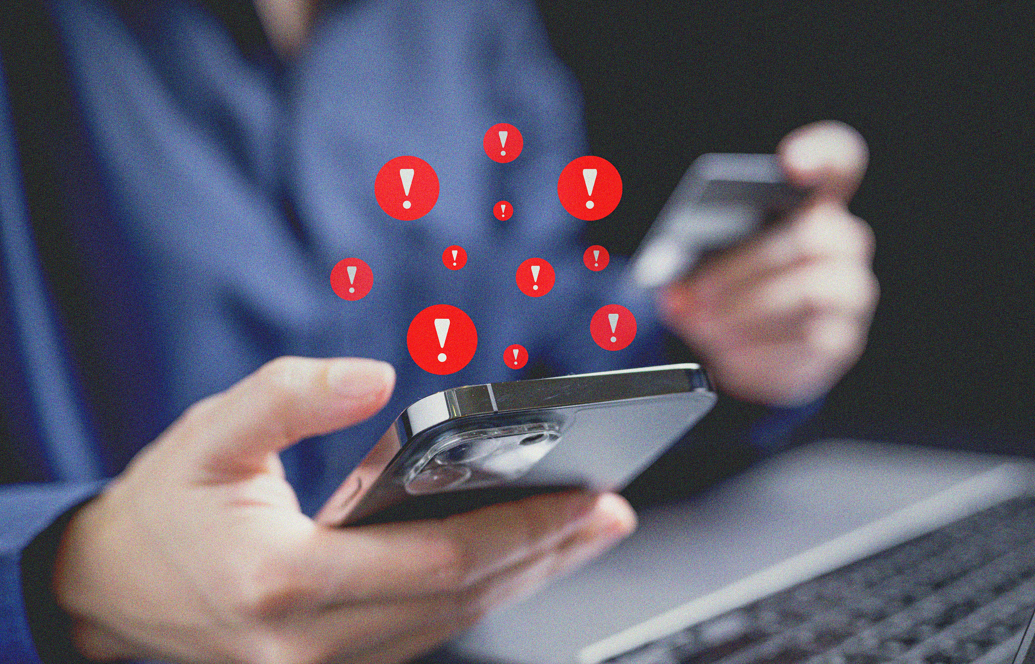a person holds an iphone, with red alert icons hovering above the screen