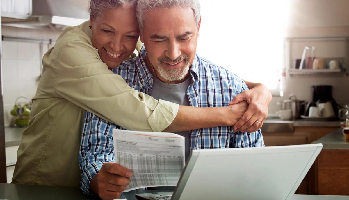 Couple hugging and looking at bills