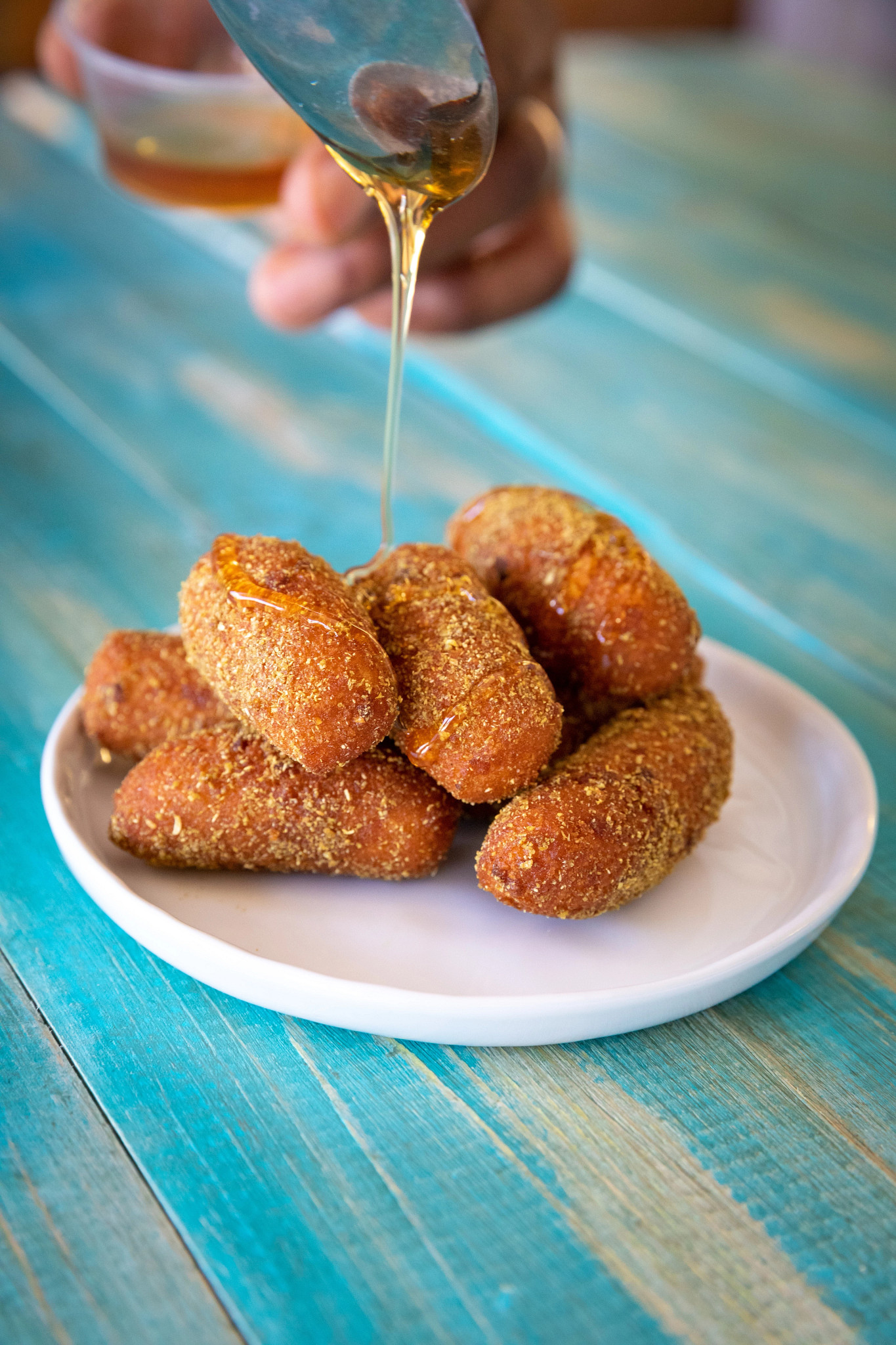 a close up of honey being poured on a plate of hush honeys