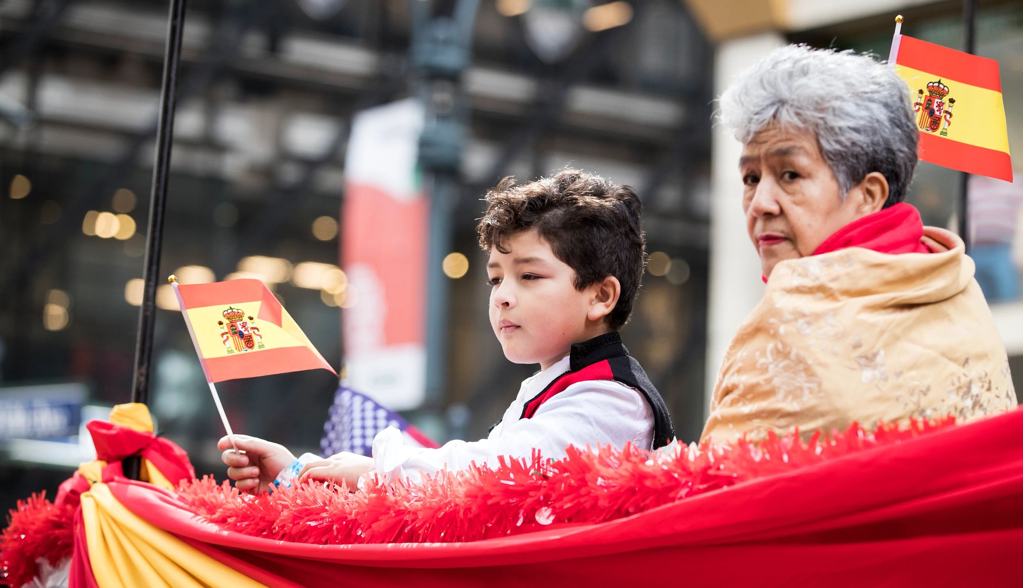 Desfile del Día de la Hispanidad en NY Una mujer y un niño sostienen banderas en el Desfile del Día de la Hispanidad