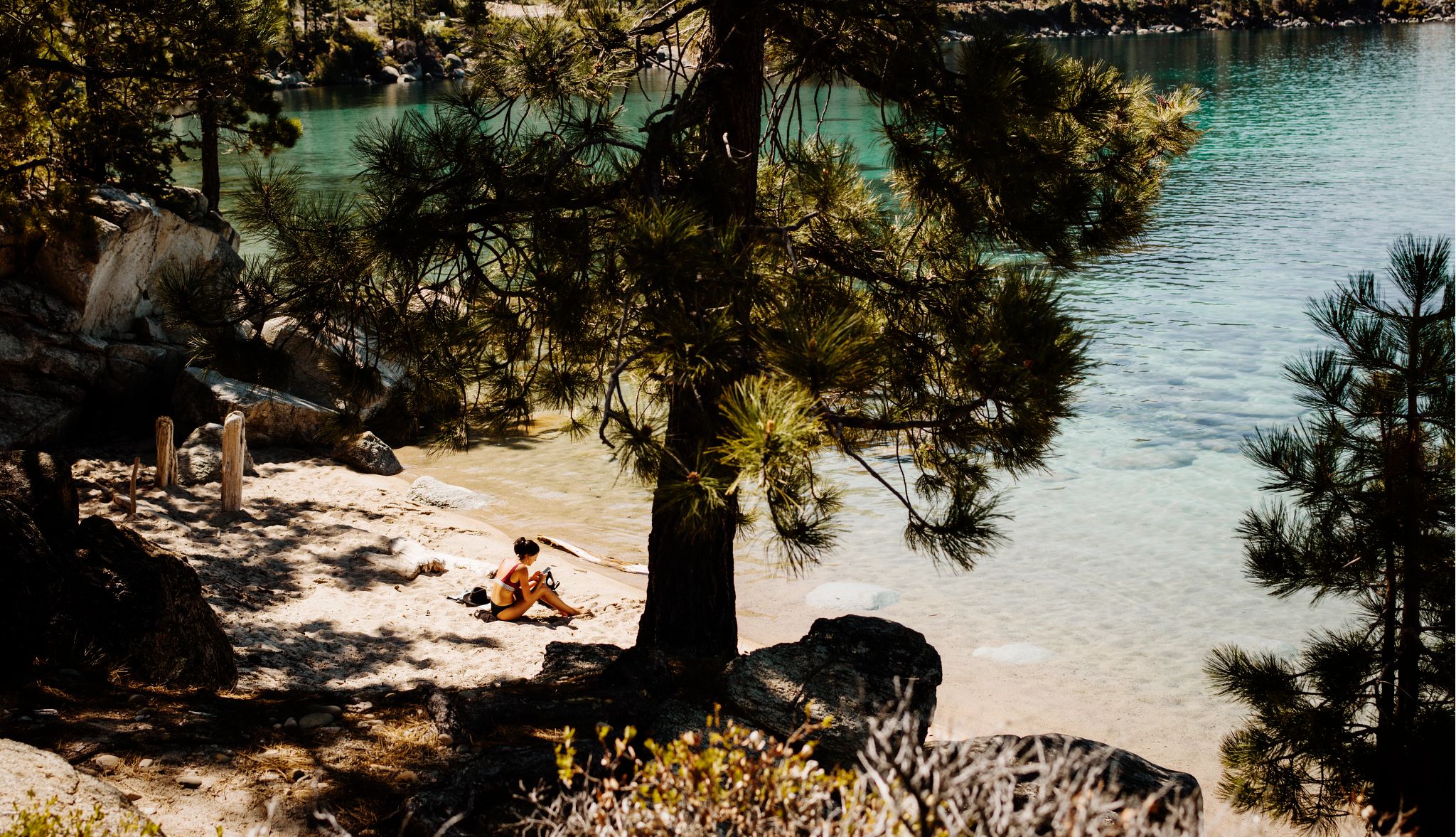 Lake Tahoe has many outdoor attractions a woman sitting along a beach in Lake Tahoe