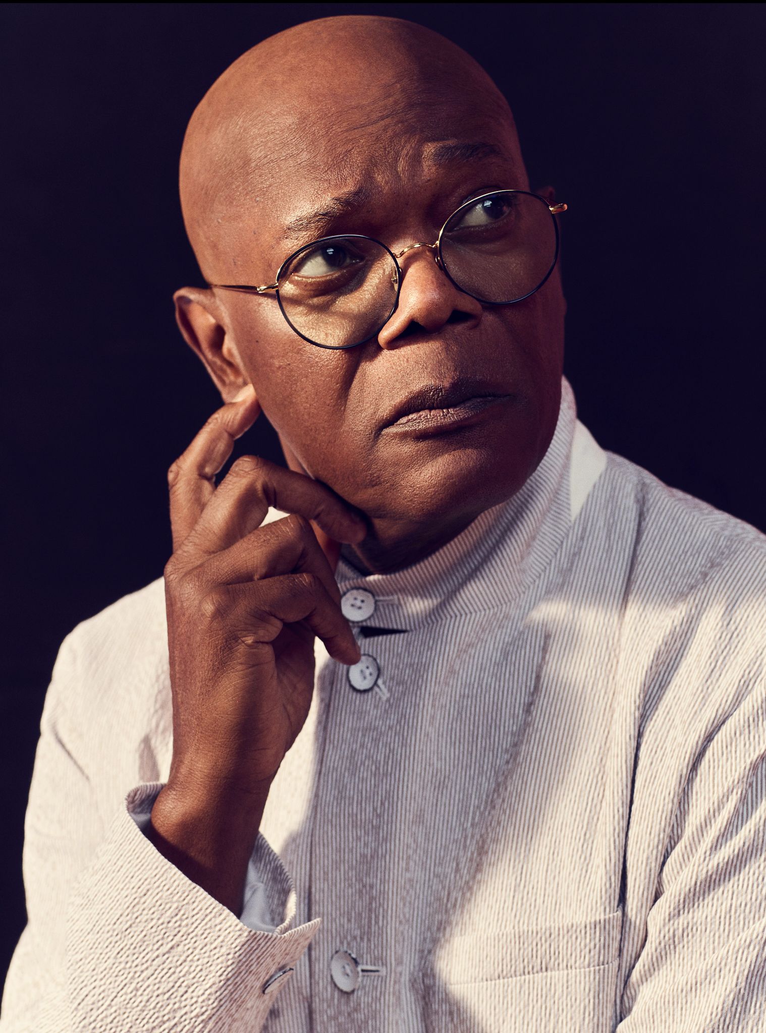 Samuel L. Jackson Samuel L Jackson posing for a portrait as he wear glasses and has his fingers placed on the side of his face
