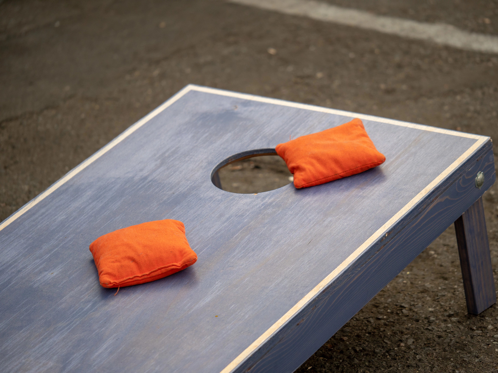 A photo shows two beanbags on a cornhole board