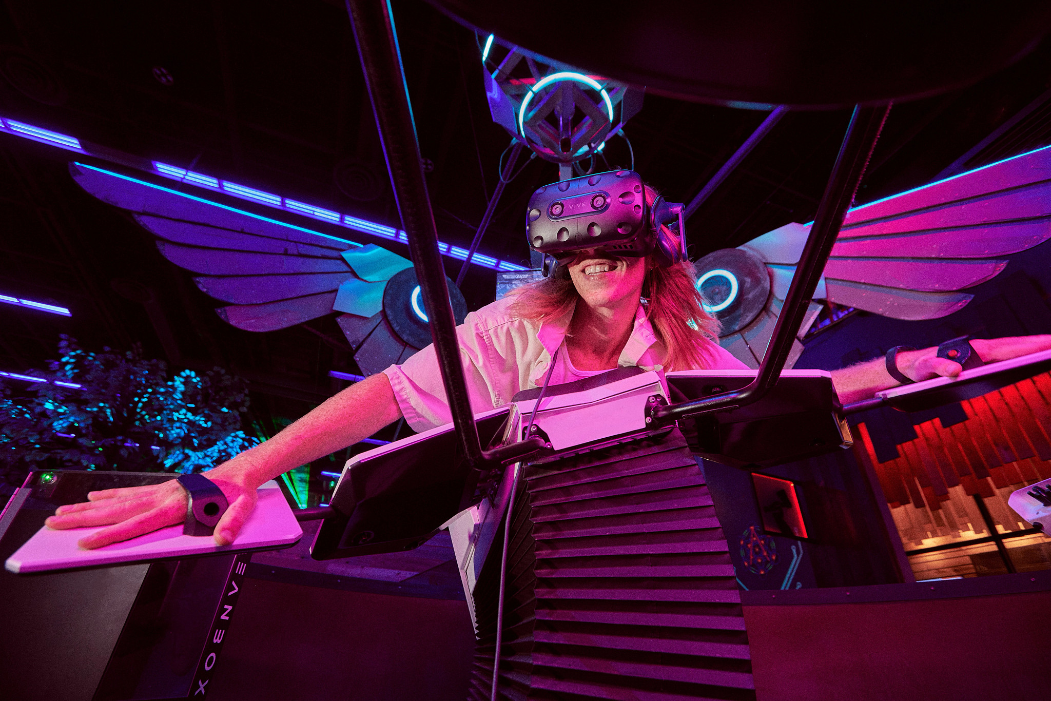 Person in contraption with wings, wearing virtual reality headgear
