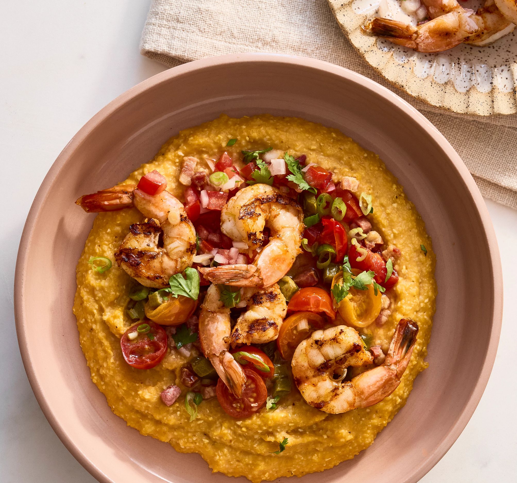 Recipes That Will Make You Love Pumpkin A photo shows cheesy pumpkin grits with grilled shrimp scampi