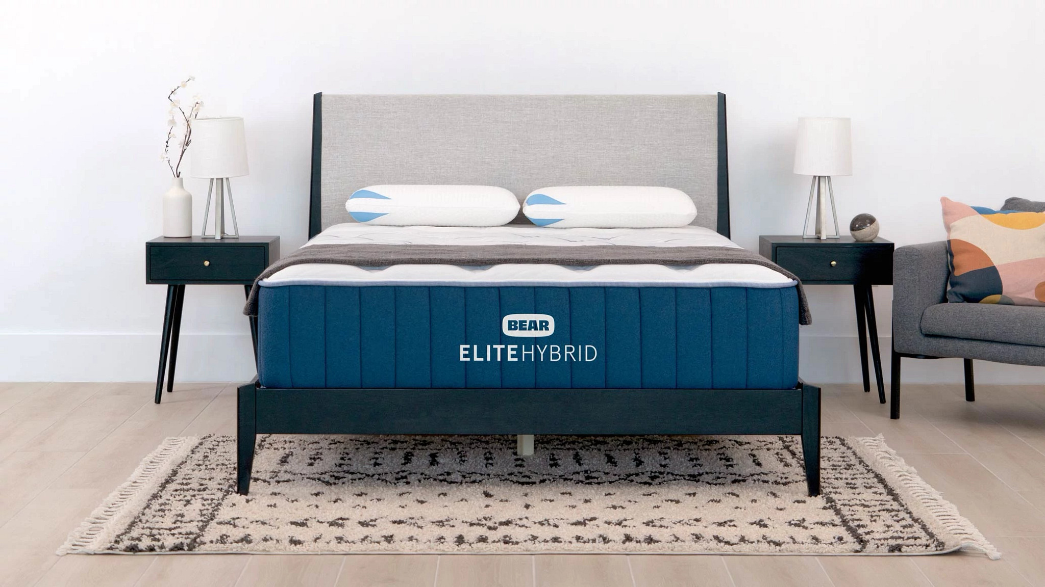 The Bear Elite Hybrid mattress in a bedroom with two nightstands on either side.