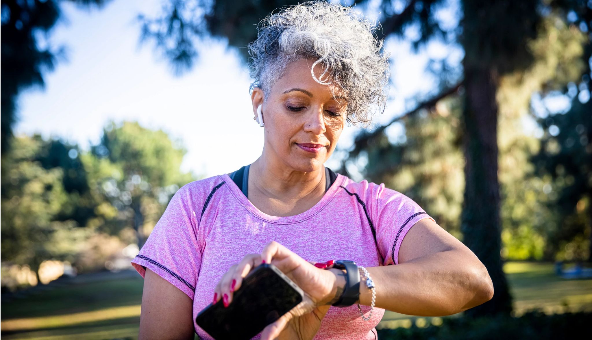 Una mujer se ejercita al aire libre usando su reloj inteligente