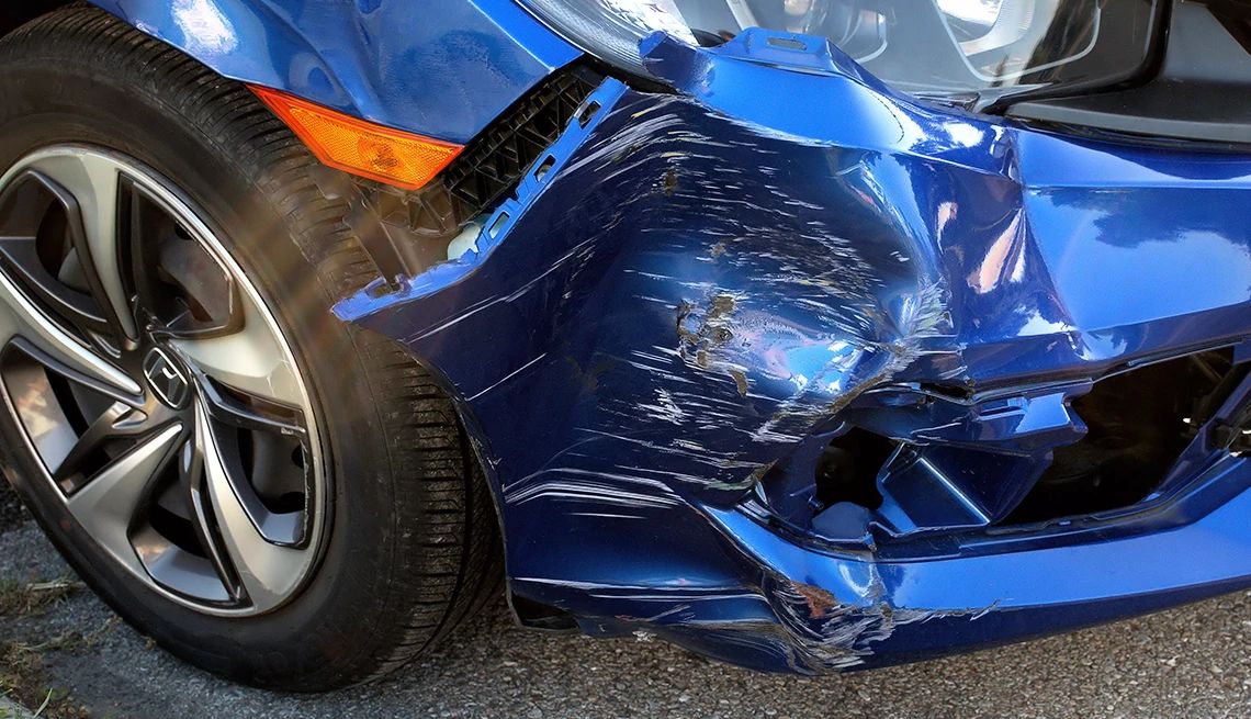 A heavily damaged car a blue car with heavy body damage