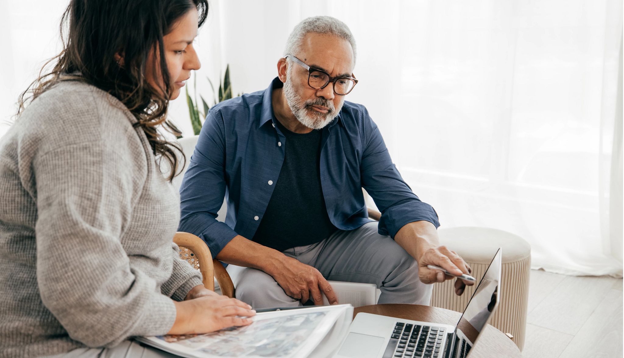 Younger woman and older man looking at a laptop Younger woman and older man looking at a laptop