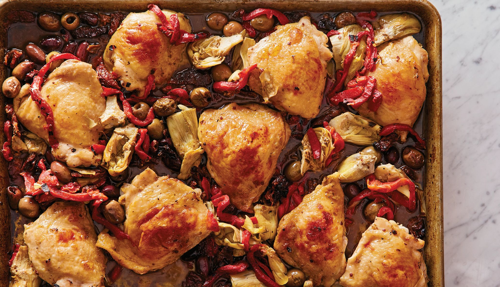 Olive Bar Chicken Recipe olives and chicken thighs on a sheet tray