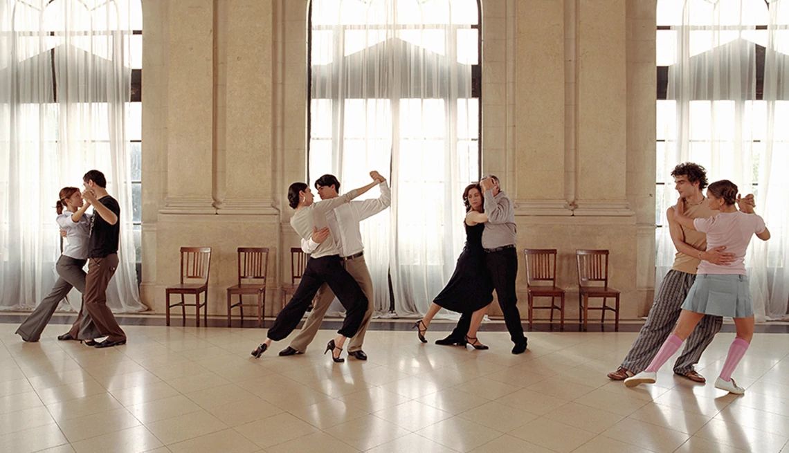 Dancing increases the brain's mental flexibility Four sets of men and women ballroom dancing in an open room