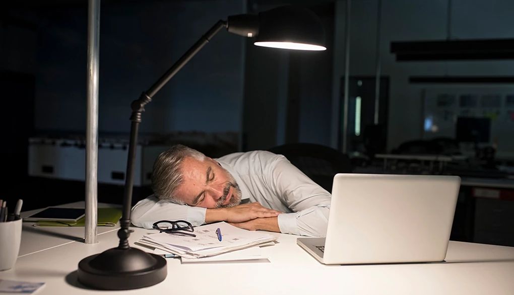 Long, late-in-the-day naps can disrupt sleep at night A man napping at a desk at night