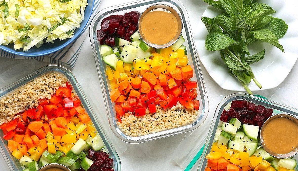 Chopped rainbow salad bowls with peanut sauce An overhead view of chopped rainbow salad bowls with peanut sauce