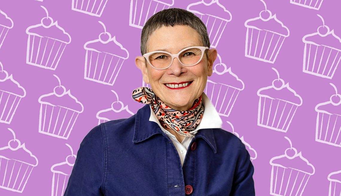 Dorie Greenspan Cakes It Up a photo shows dorie greenspan in front of a purple cupcake-themed backdrop