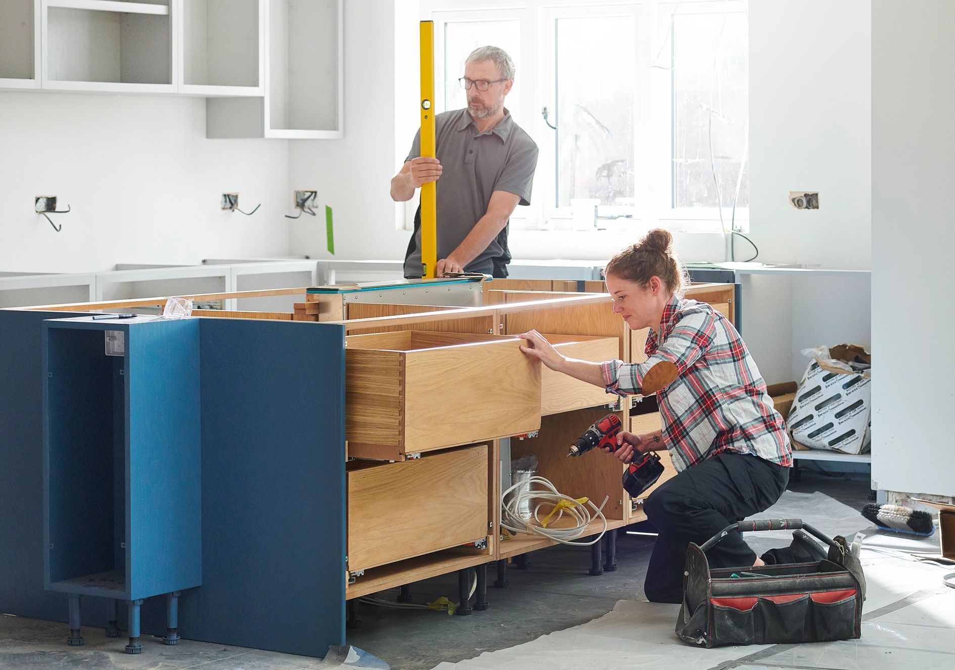two people work on building a kitchen island
