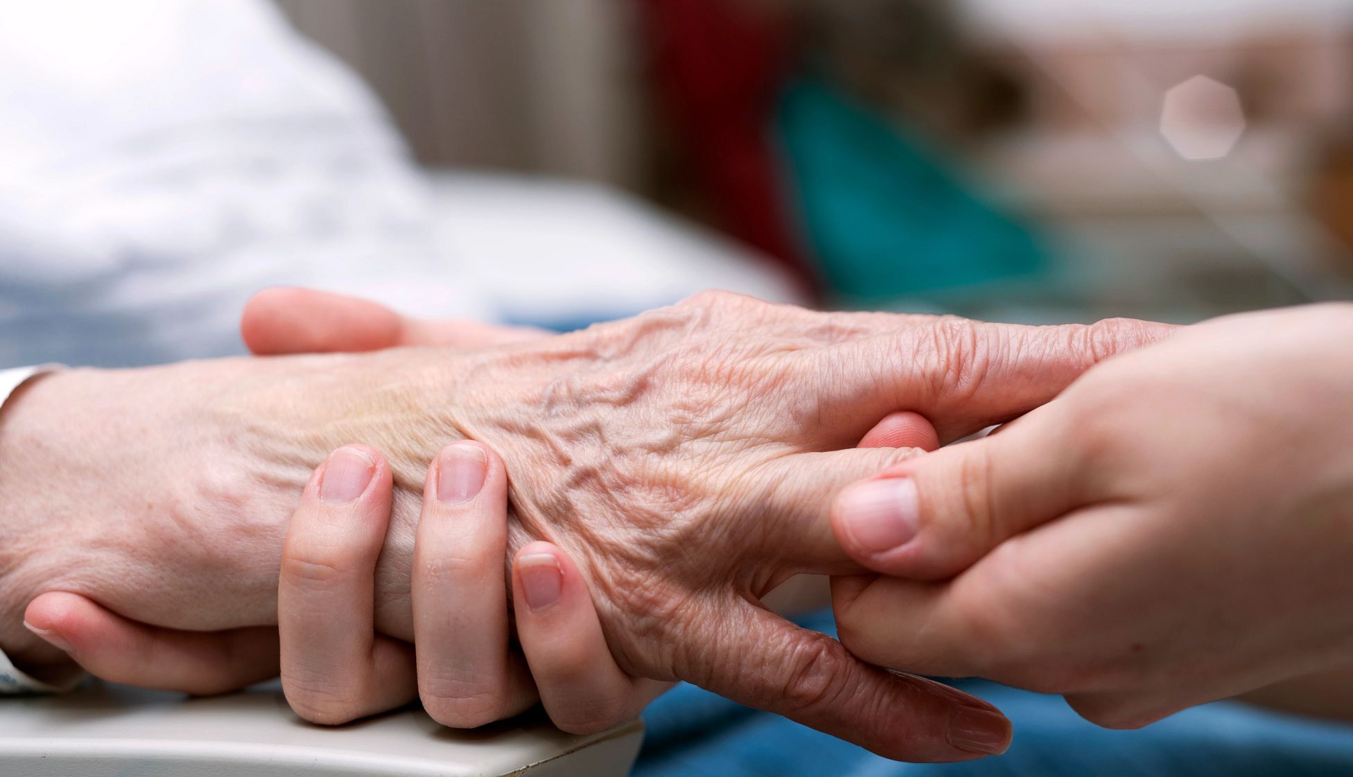 A caregiver massages the hands of someone with arthritis