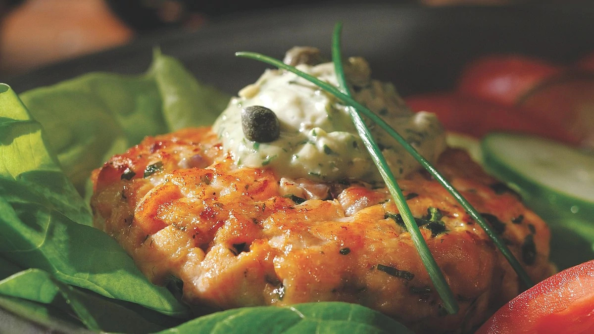 A close-up view of salmon burgers with green goddess sauce