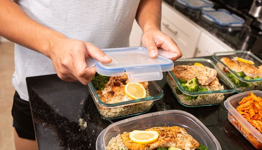 Meal planning may give you an edge when it comes to eating well A man putting away a salmon meal prep meal into containers