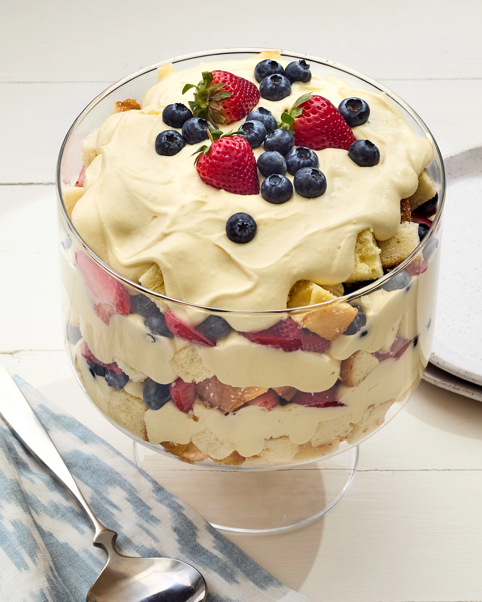 A Fourth of July Trifle dessert is pictured in single serving, with a topping of blueberries and strawberries. 