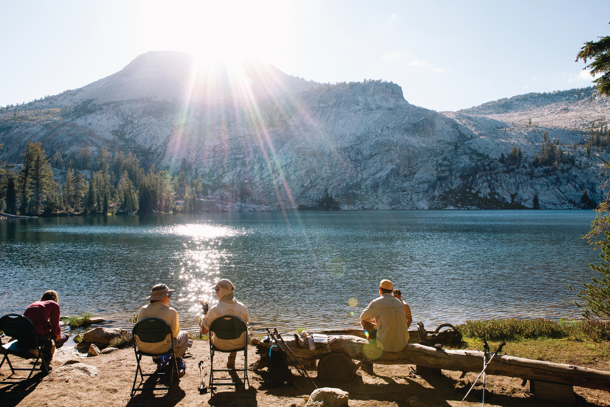 people sitting on chairs by a lake