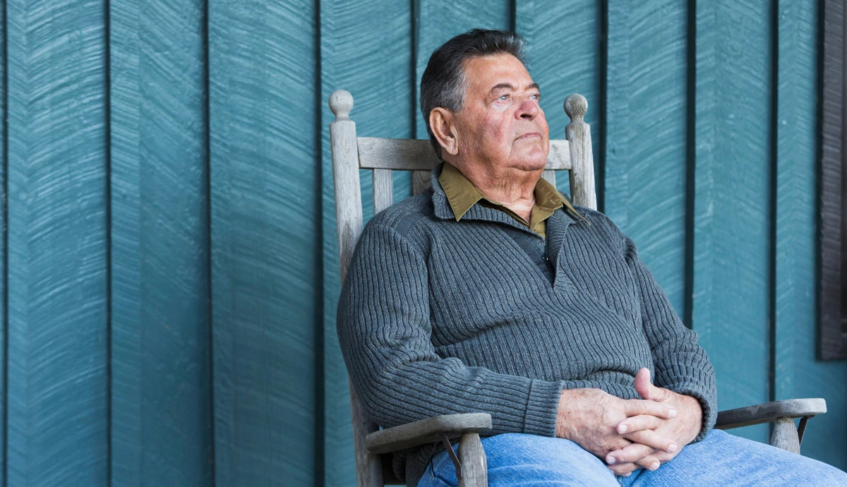 Man sitting in rocking chair looking pensive