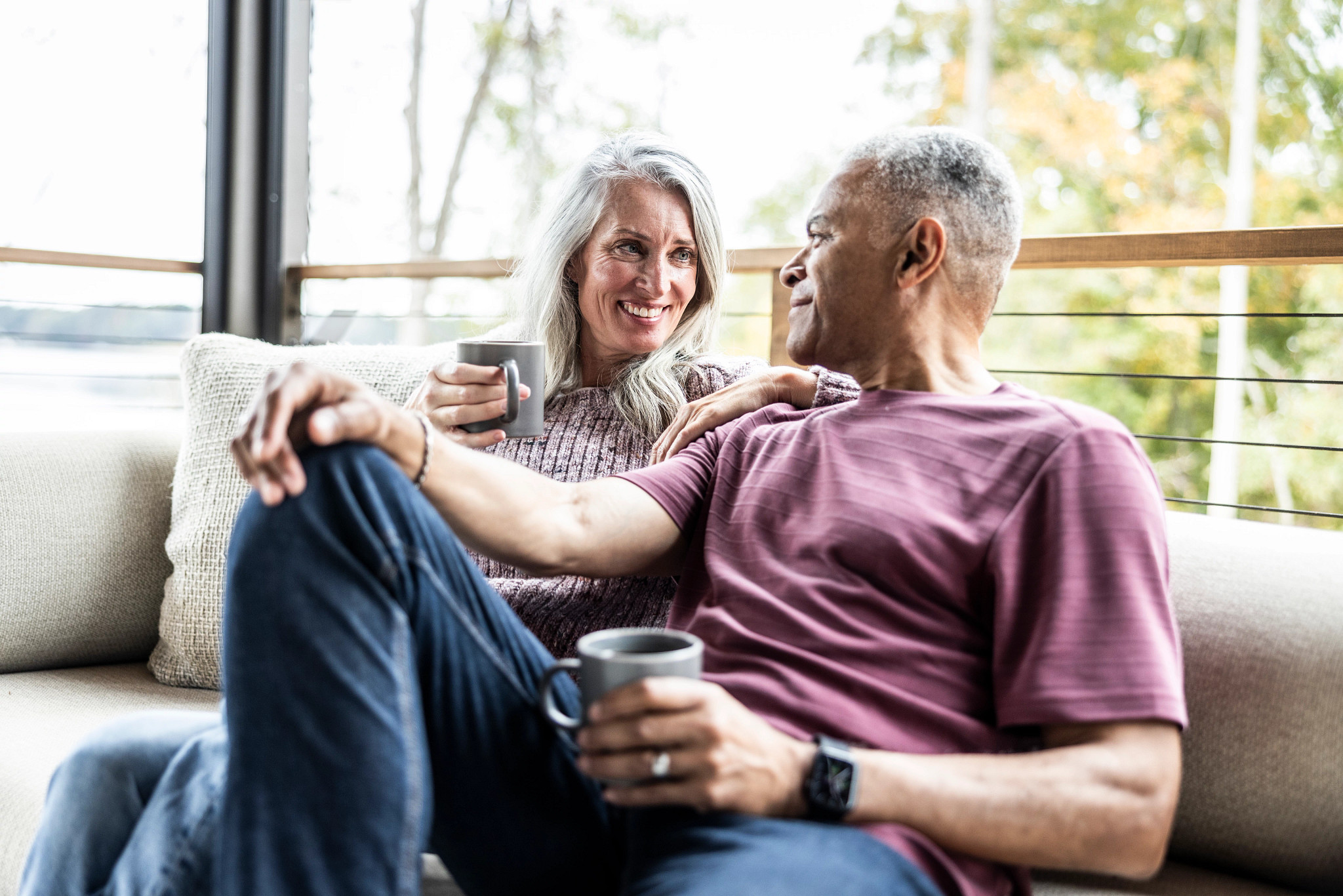 a photo shows an older adult couple is shown relaxing on a couch