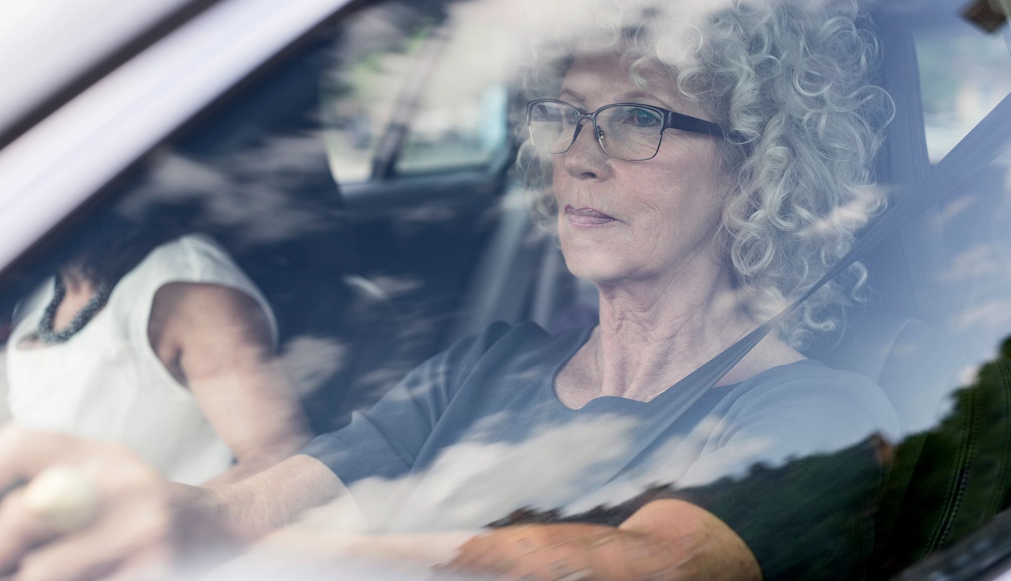 Mujer mayor conduce un auto
