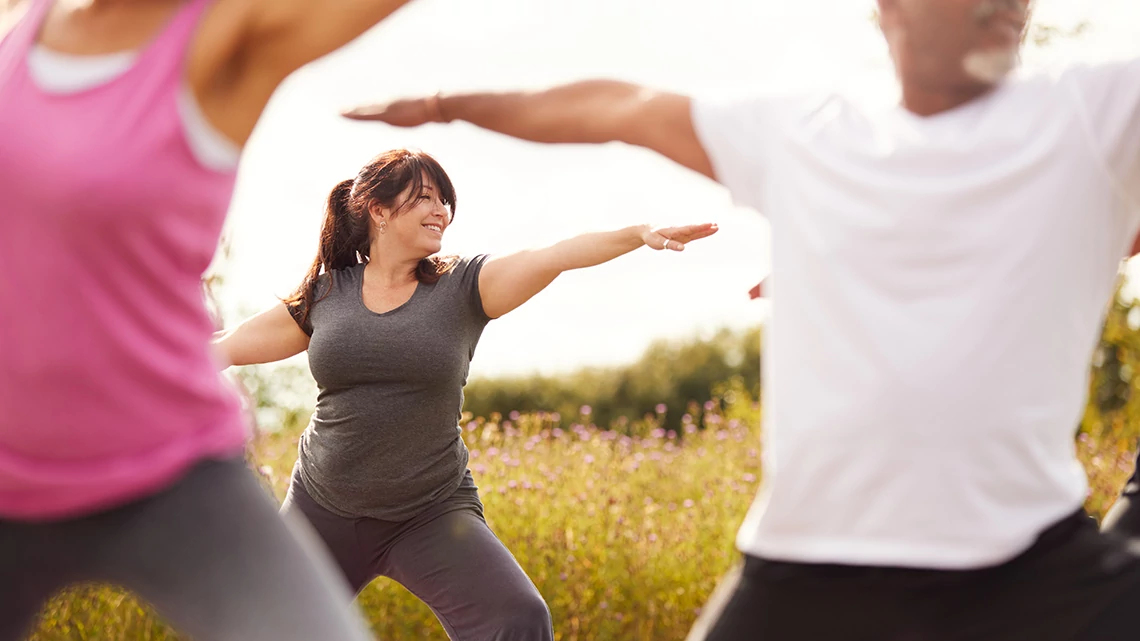 Group Of Mature Men And Women In Class At Outdoor Yoga Retreat