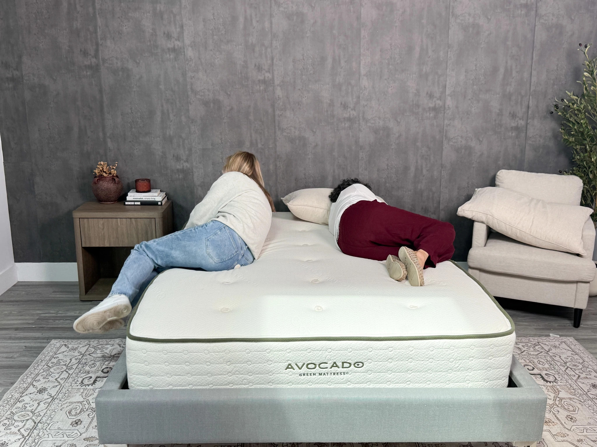 A person rolls out of bed while another lies on the other side of the mattress.