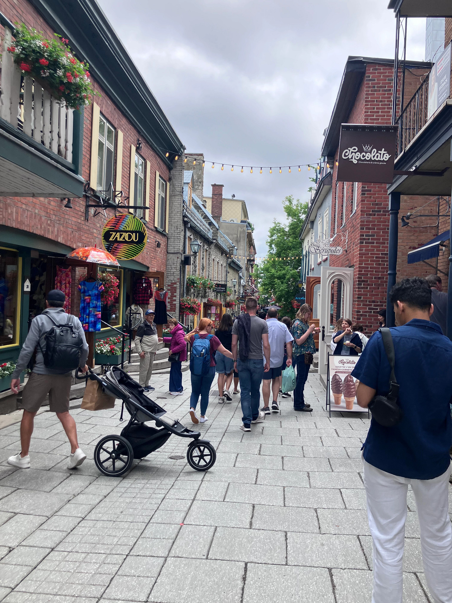 people on a street outside boutiques and cafes