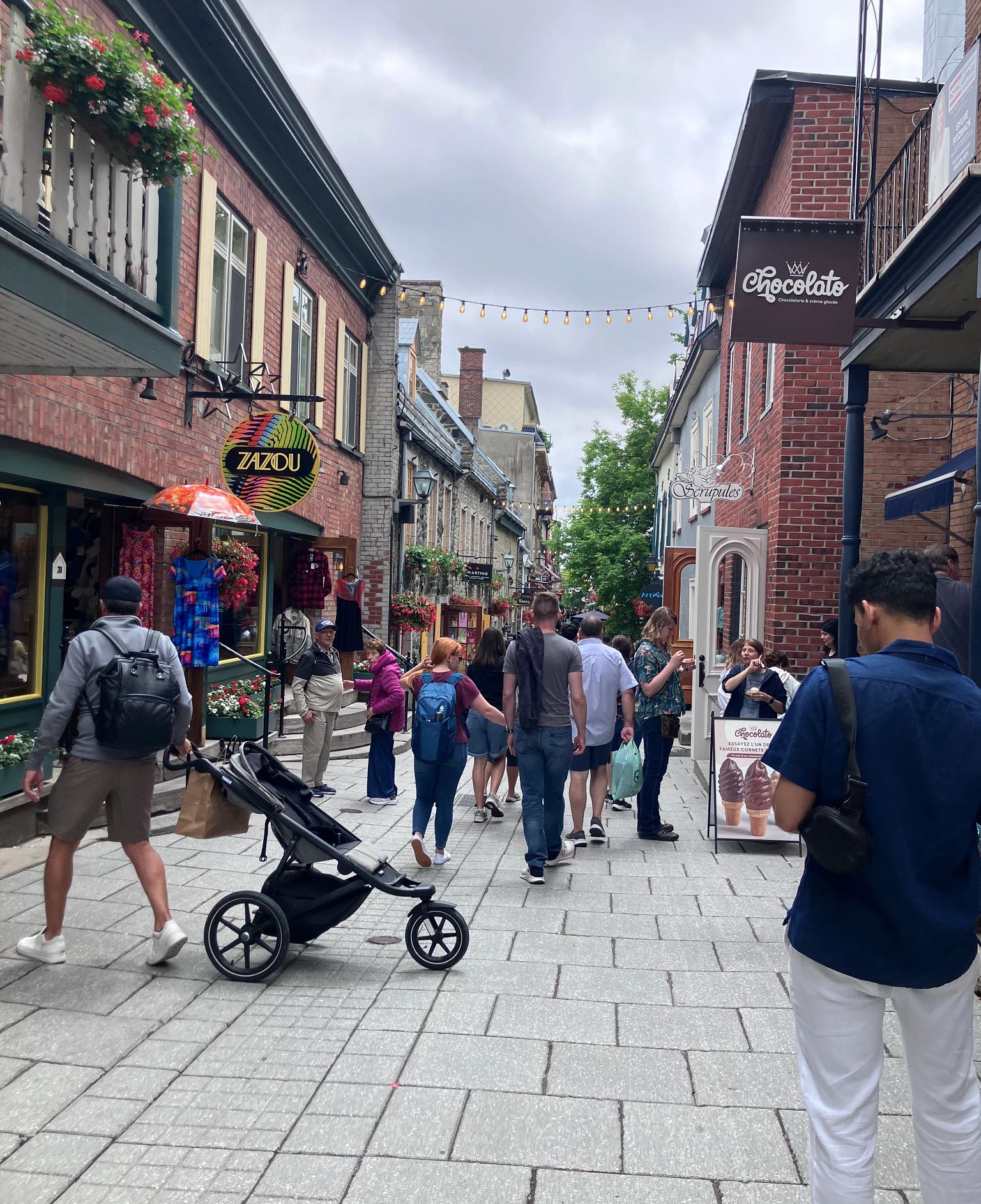 No Cash Overseas Lessons people on a street outside boutiques and cafes