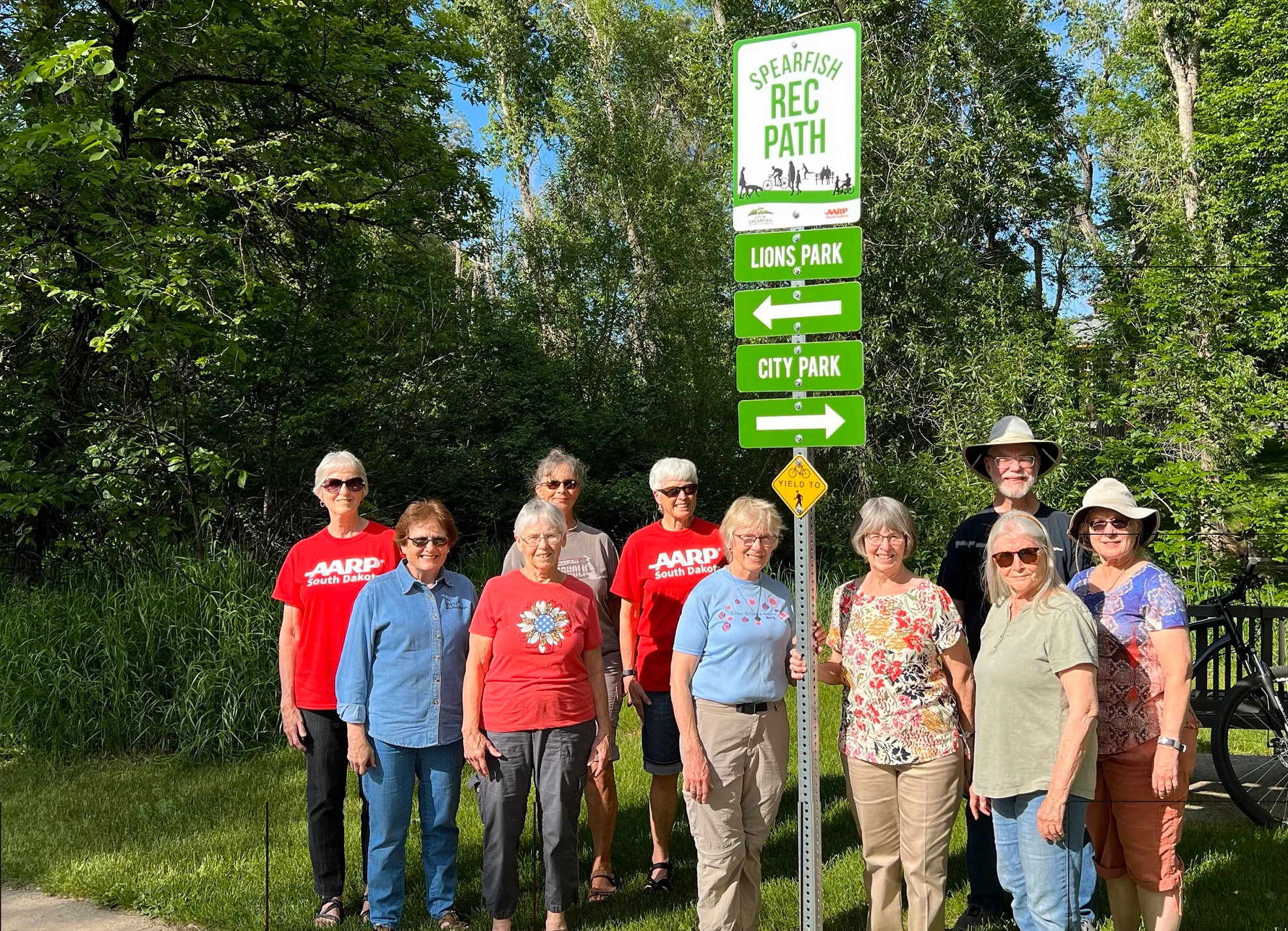 Group of aarp volunteers taking a photo with Spearfish sign