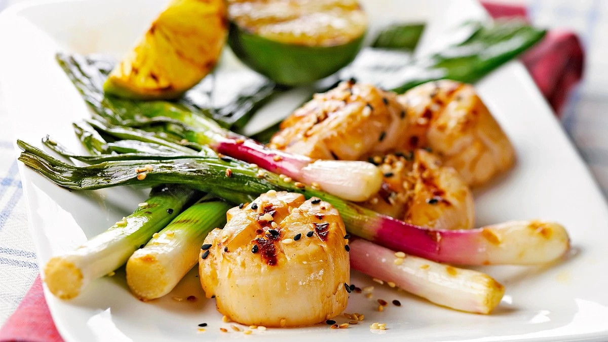 A close-up view of soy-lime scallops with leeks on a plate