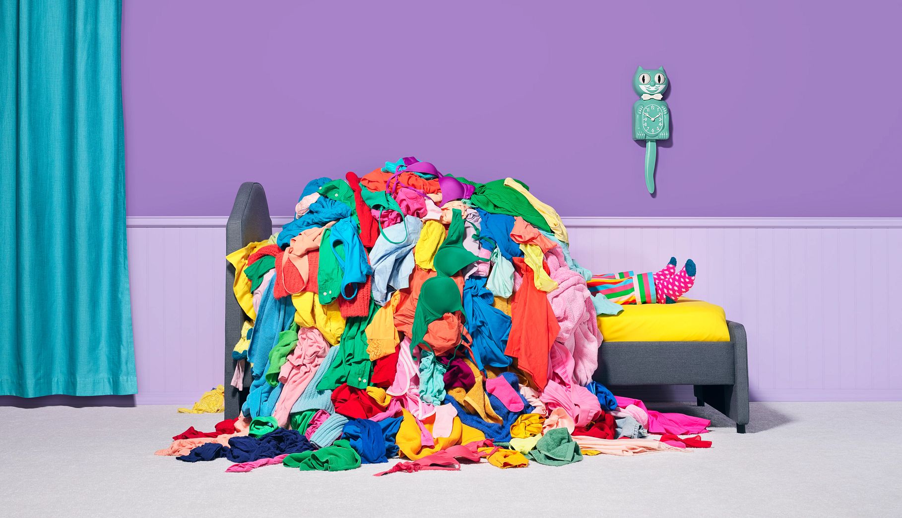 Refresh Your Wardrobe and Beauty Products a person lying underneath a large pile of discarded clothing