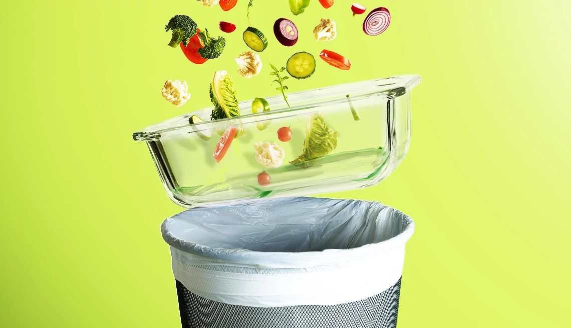 Smart Guide to Reducing Food Waste Different vegetables in air above glass dish above garbage can