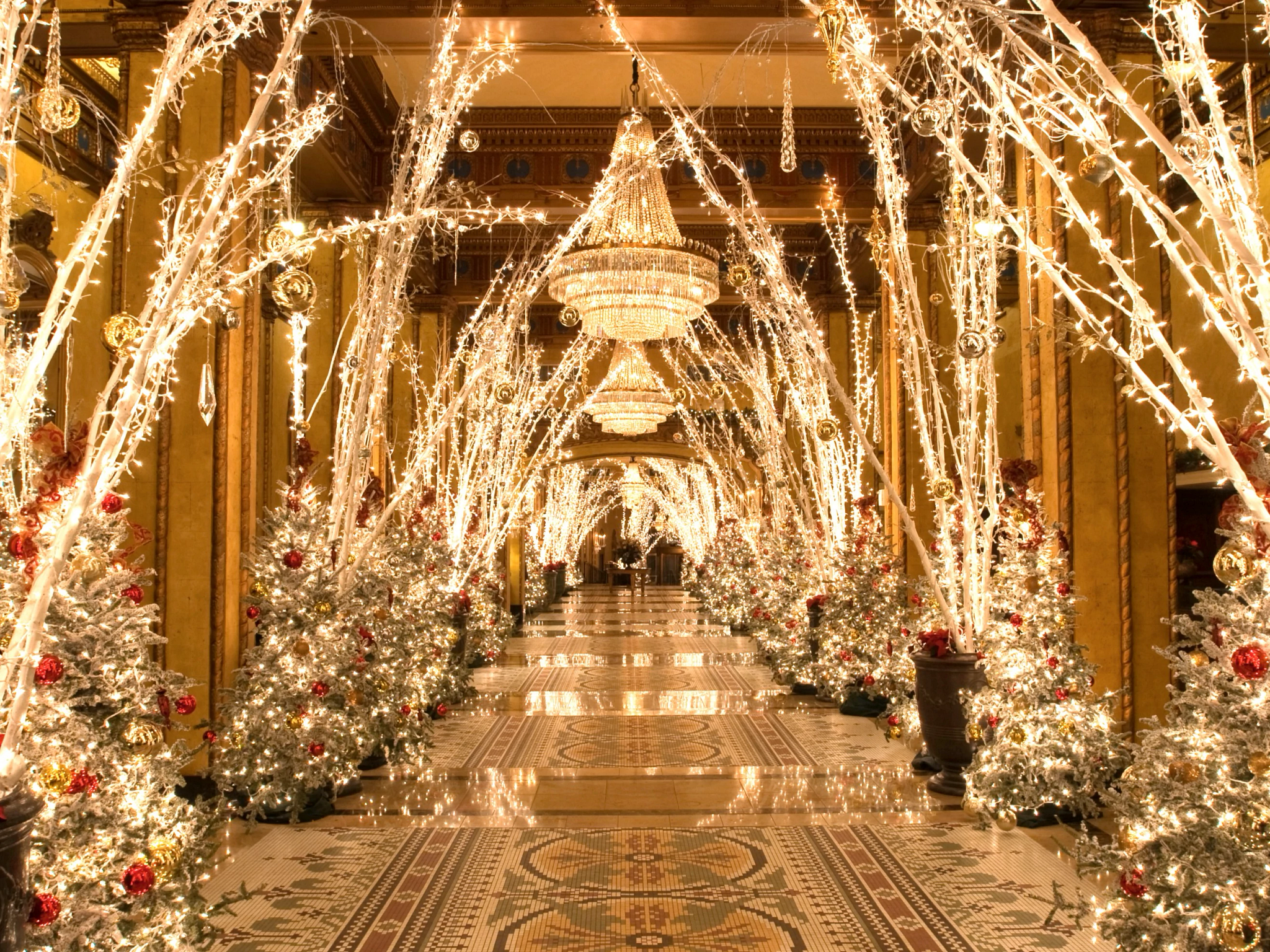 christmas trees and lights line the hallway of a hotel
