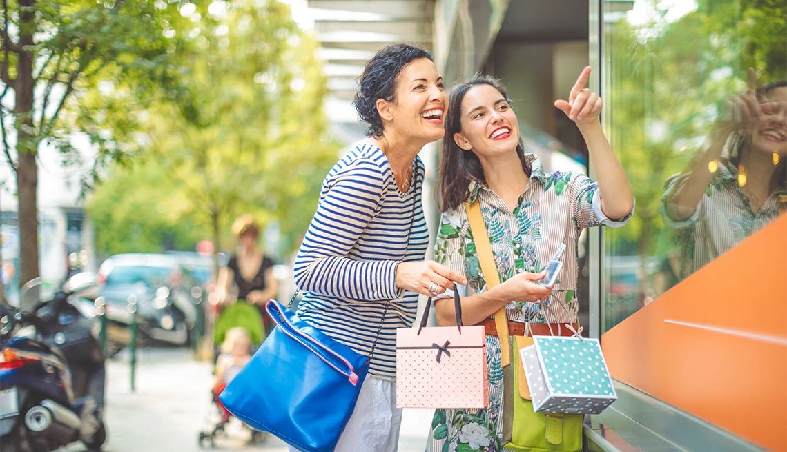 Shopping Category Two women window shopping holding shopping bags