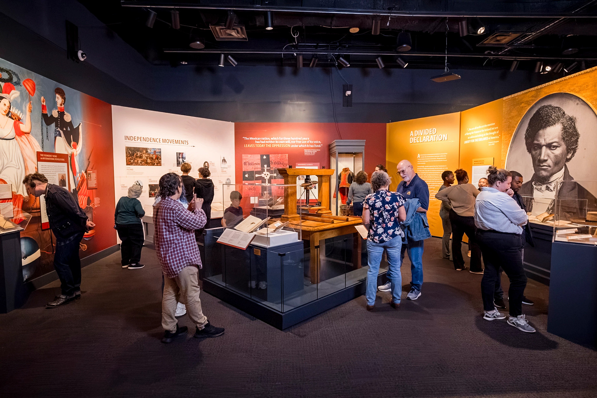 people walking around and observing inside the museum of the american revolution