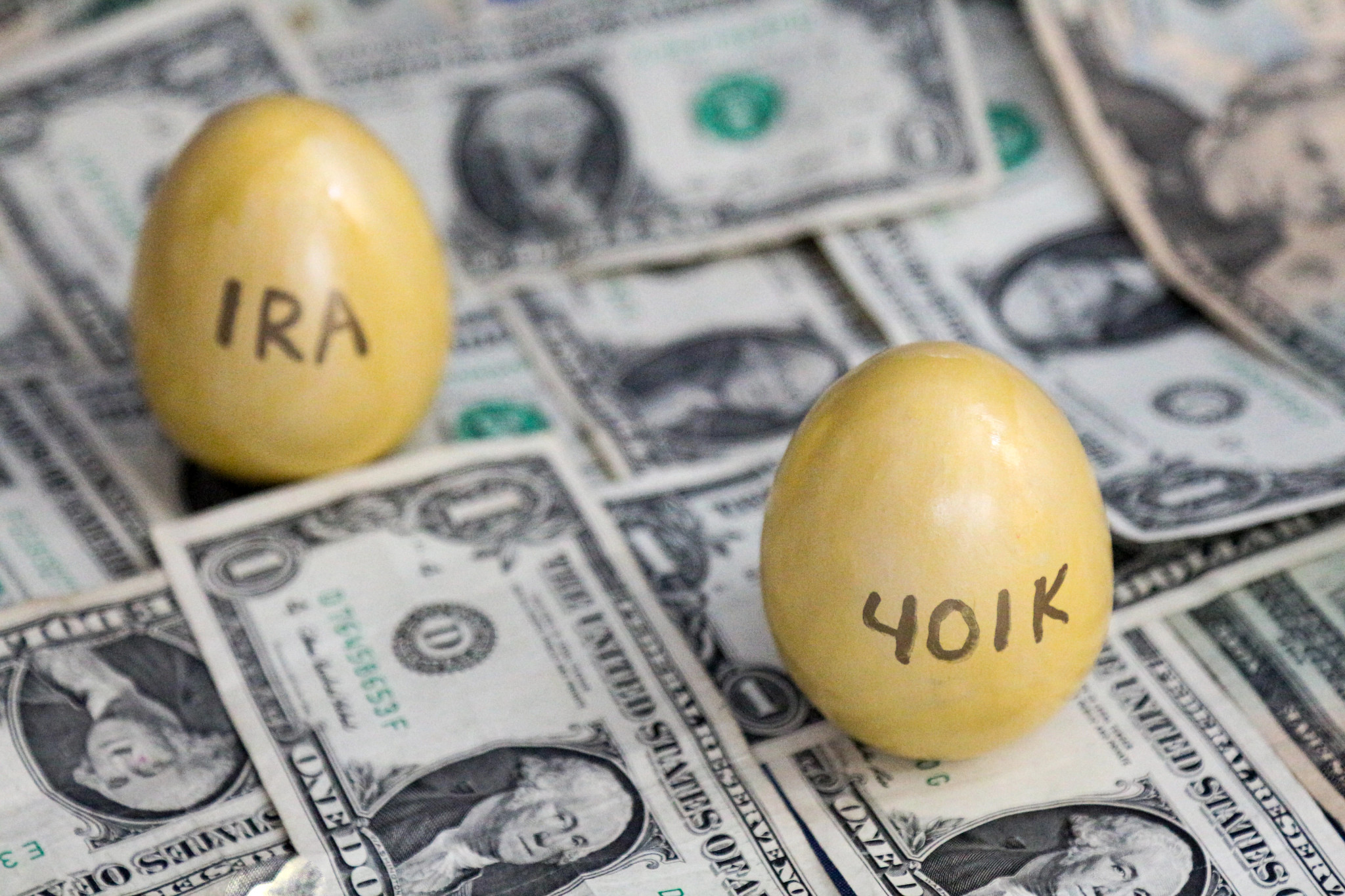401k and IRA golden eggs on one dollar bills