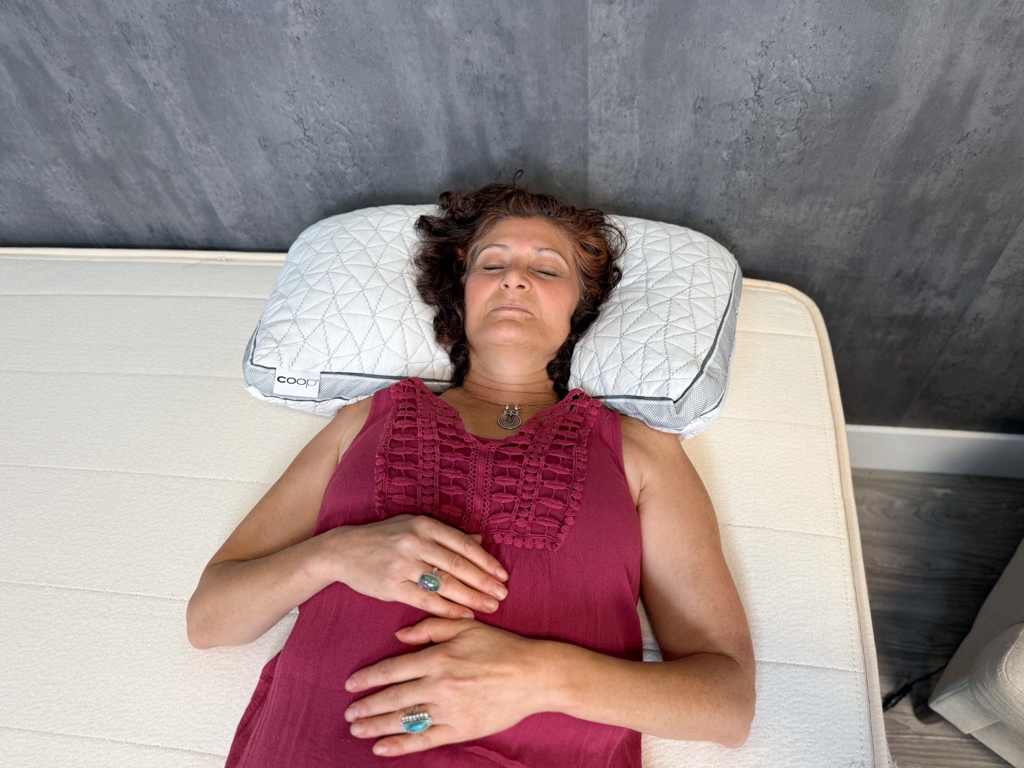  A person lying on their back on a mattress and a pillow