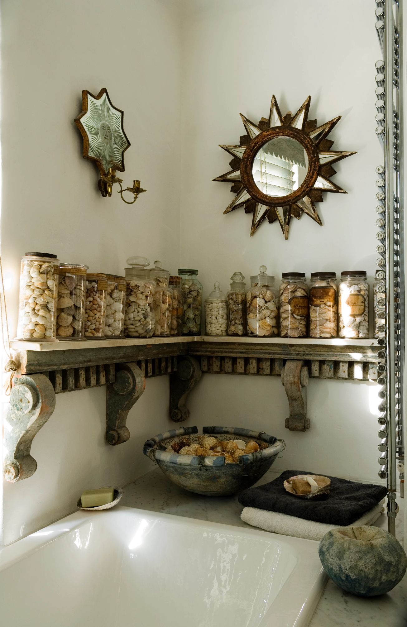 rocks in jars displayed on a shelf over a bathtub