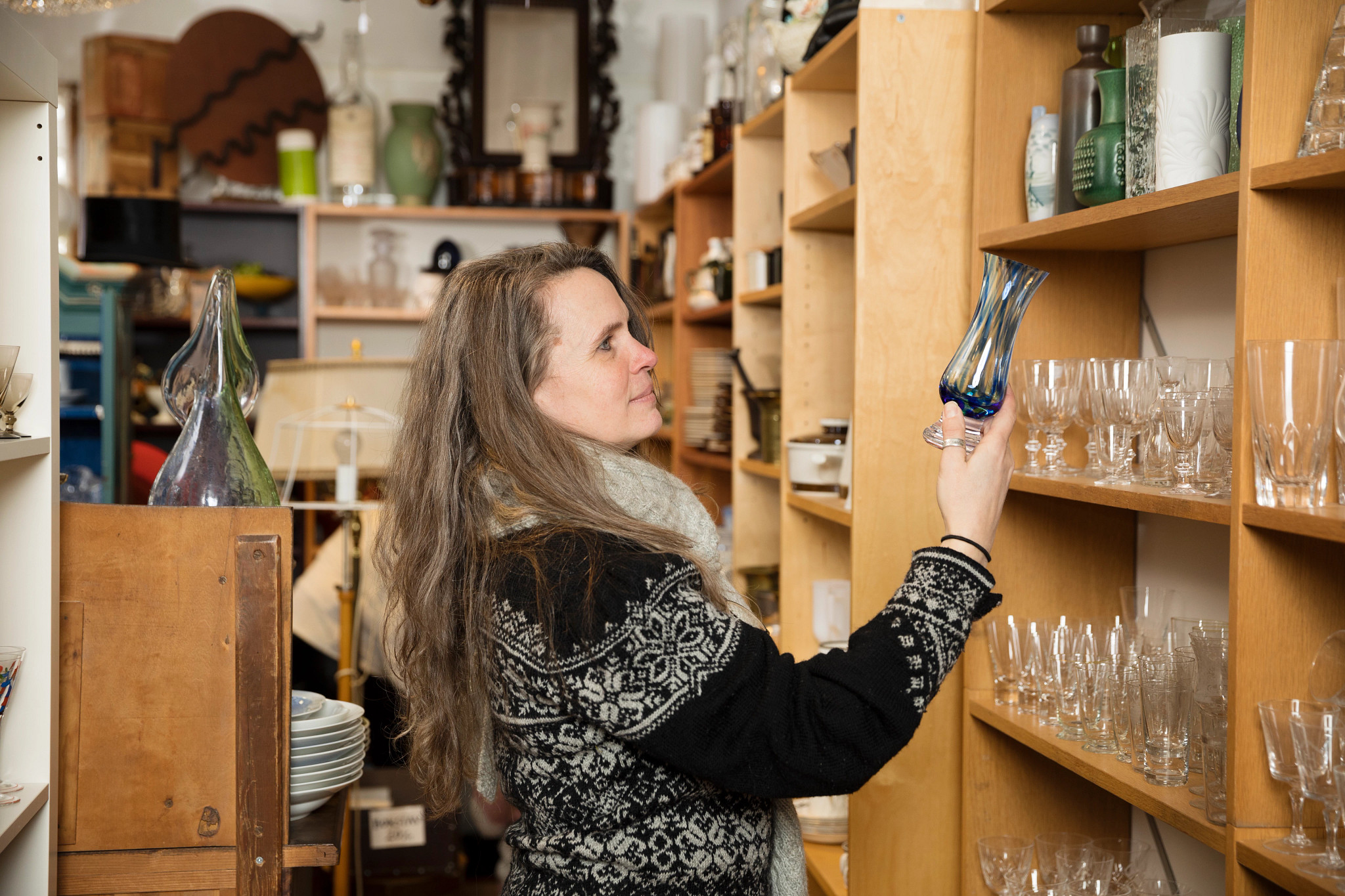 a photo shows a woman perusing antiques in a store