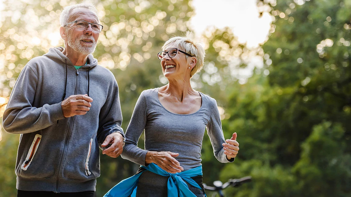 Smiling senior couple jogging in the park