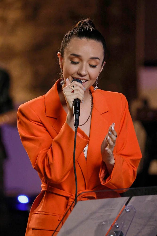 The Voice contestant Maddi Jane singing into a microphone during The Battles Part 2 of Season 25