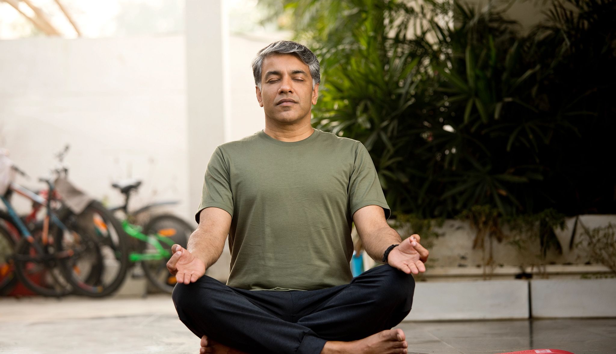 Woman sitting on yoga mat in relaxed pose Woman sitting on yoga mat in relaxed pose