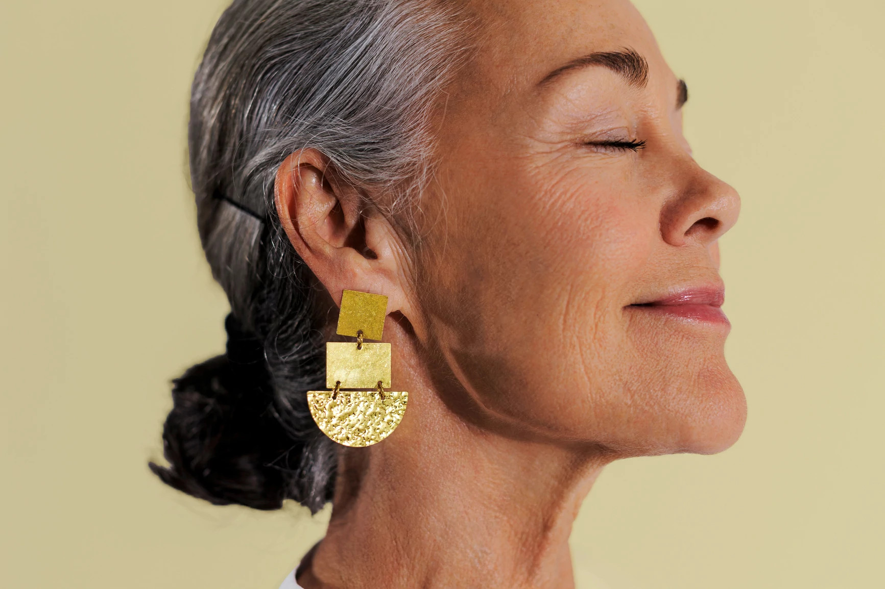 side view of gray haired female with closed eyes